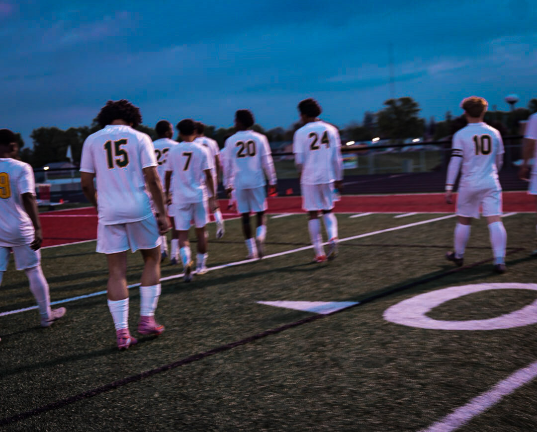 High school soccer team walking onto the field at dusk in Cedar Rapids, Iowa